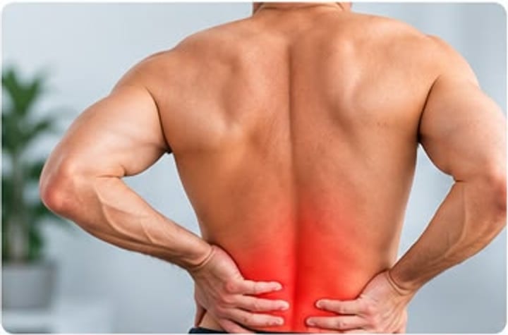 Hombre de espaldas sujetándose la zona lumbar, con la zona dolorida marcada en rojo.
